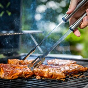 person holding gray tongs on barbecue